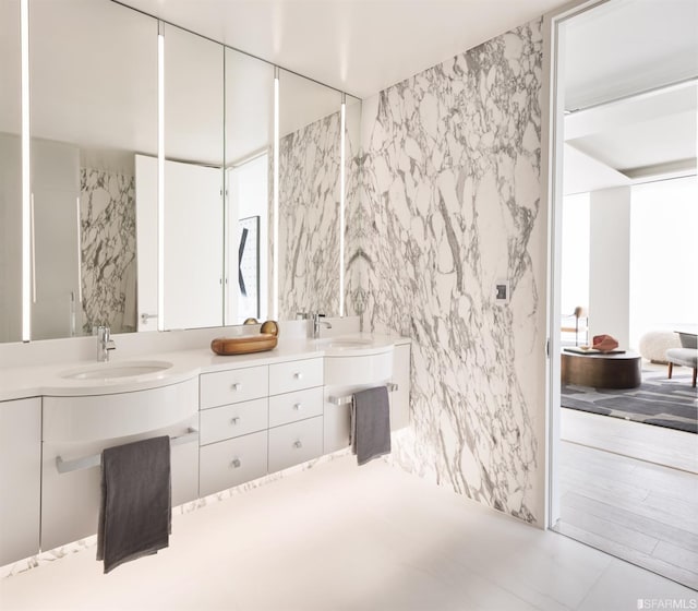 bathroom featuring double vanity, tile walls, and a sink