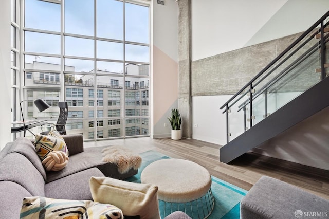 living room featuring wood-type flooring and a towering ceiling