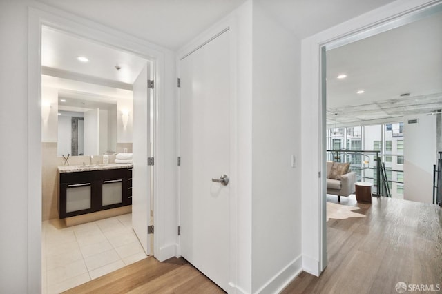 hallway featuring wood-type flooring and sink