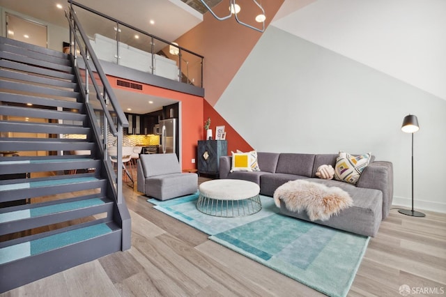 living room featuring a towering ceiling and light hardwood / wood-style floors