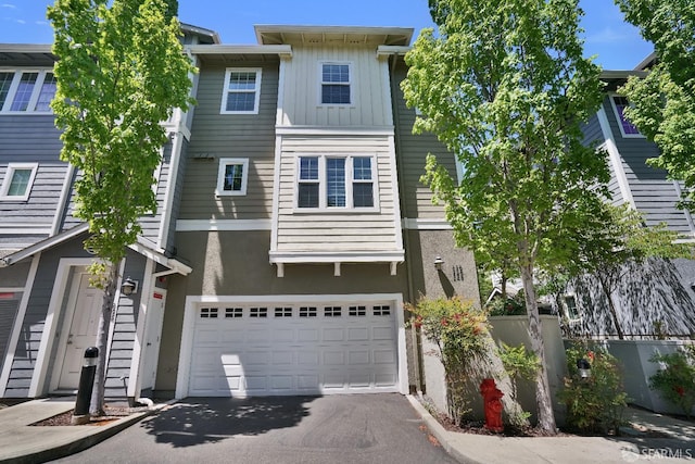 multi unit property featuring driveway, an attached garage, stucco siding, and board and batten siding