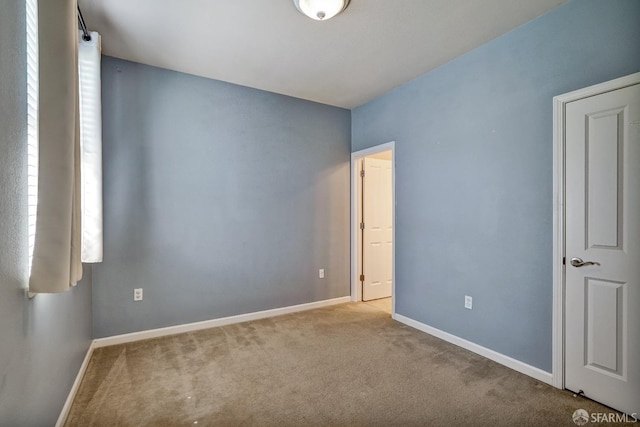unfurnished bedroom featuring carpet floors and baseboards