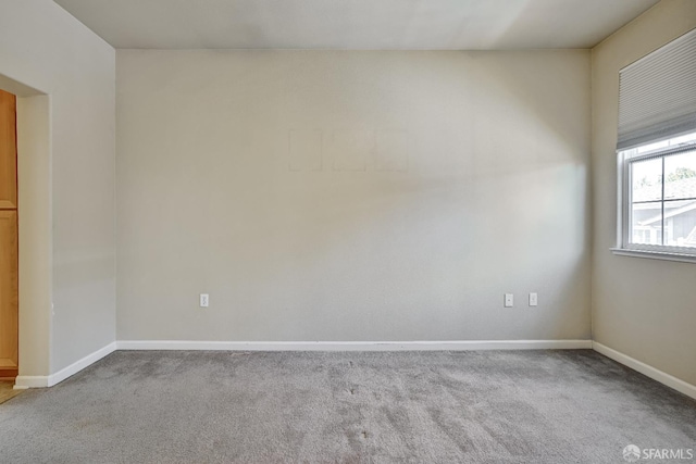 empty room featuring carpet flooring and baseboards