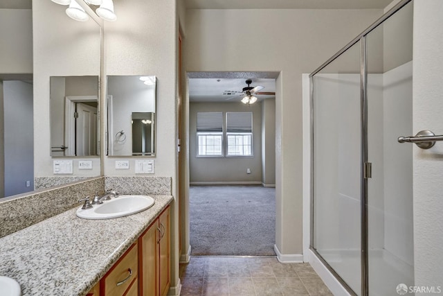 bathroom featuring a shower stall, vanity, tile patterned floors, ceiling fan, and baseboards