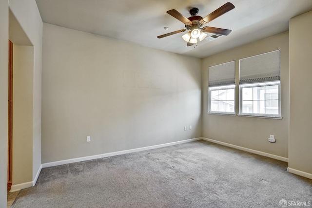 carpeted empty room with a ceiling fan and baseboards