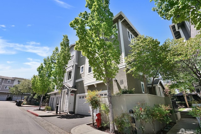 view of side of home with a garage and stucco siding
