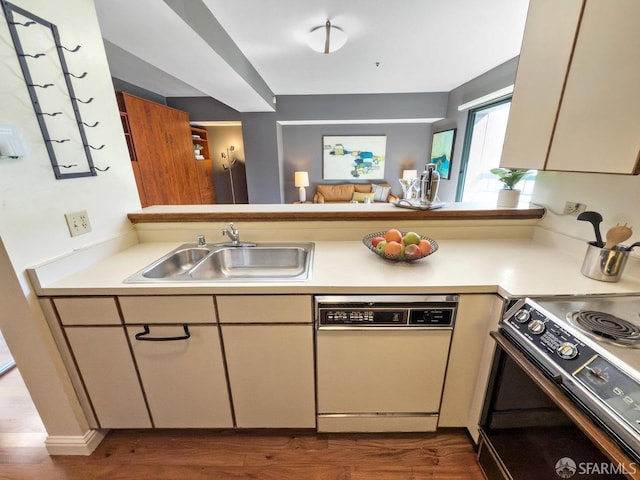 kitchen featuring dark wood-style flooring, light countertops, a sink, range with electric cooktop, and dishwasher