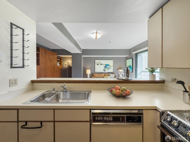 kitchen featuring light countertops, stove, white dishwasher, and a sink