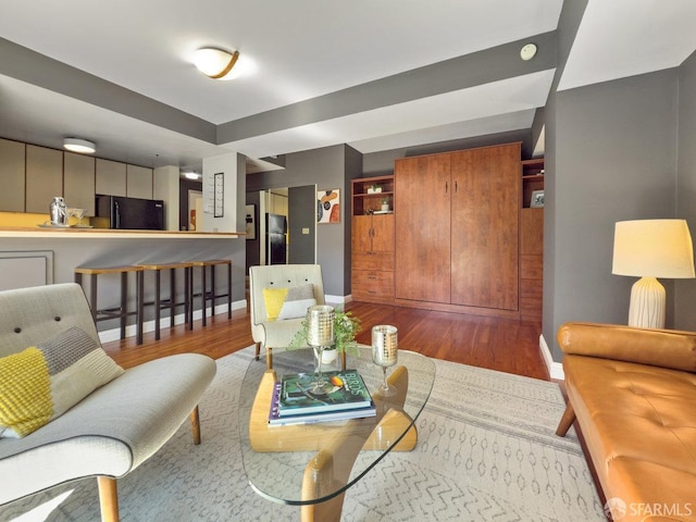 living room with baseboards and wood finished floors