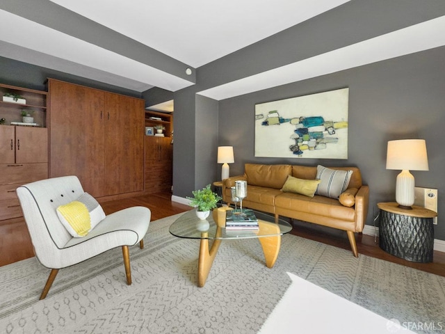 living area featuring baseboards and wood finished floors