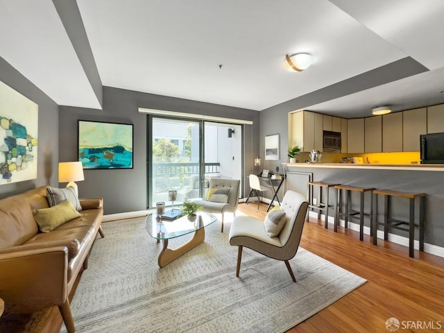 living room featuring baseboards and light wood finished floors