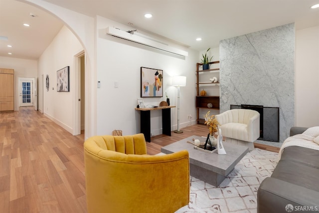 living room featuring a premium fireplace and light hardwood / wood-style floors