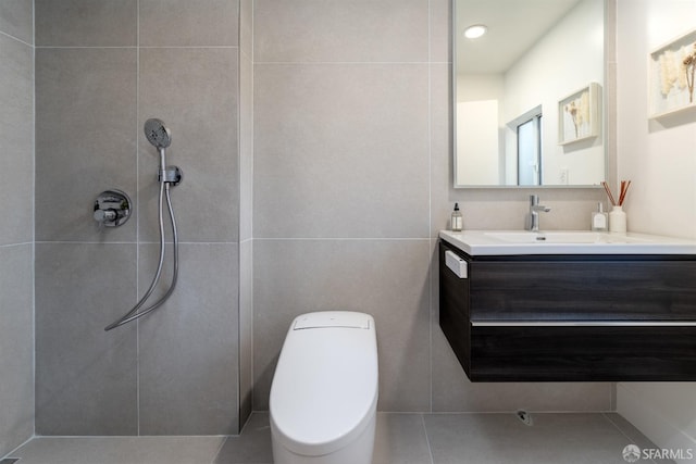 bathroom with toilet, vanity, and tile walls