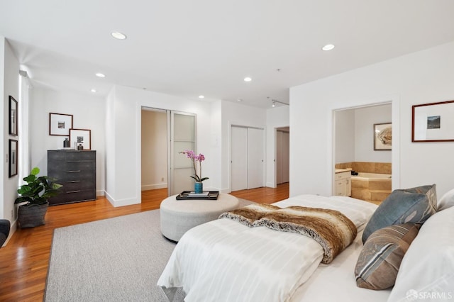 bedroom with light wood-type flooring and ensuite bath