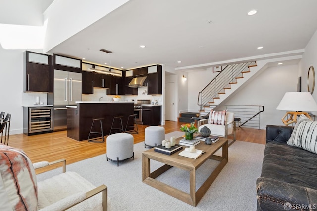 living room featuring wine cooler and light hardwood / wood-style flooring