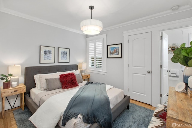 bedroom with light wood-type flooring and crown molding