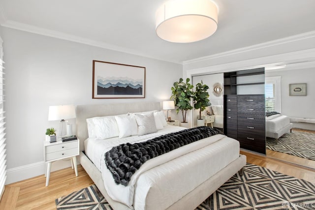 bedroom featuring crown molding, baseboards, and light wood-style floors