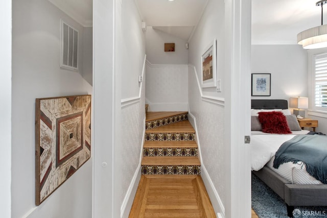 stairs featuring wood finished floors, visible vents, and baseboards