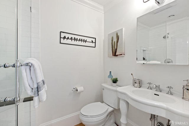 bathroom featuring ornamental molding, a stall shower, toilet, and baseboards