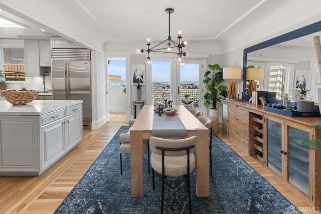 dining space featuring light wood finished floors and an inviting chandelier