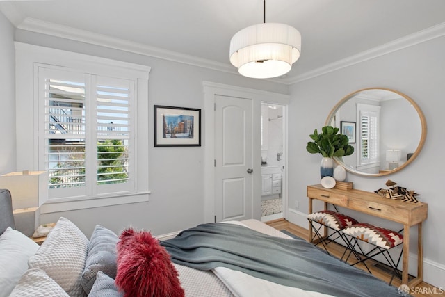 bedroom with baseboards, crown molding, and wood finished floors