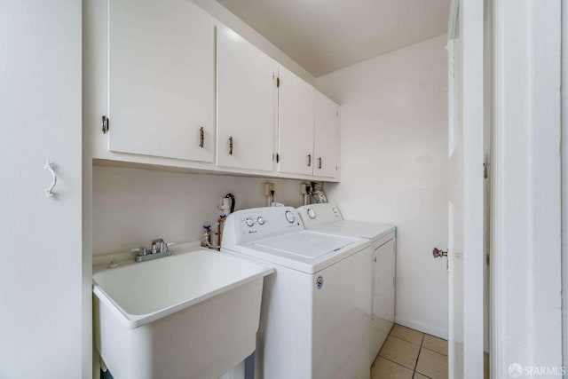 laundry area featuring washer and dryer, cabinet space, a sink, and light tile patterned floors