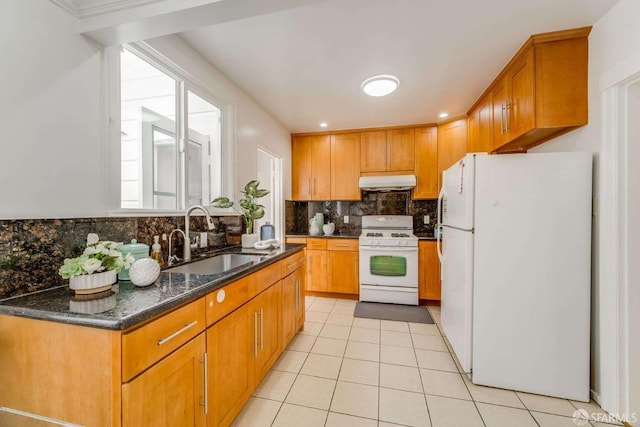 kitchen featuring light tile patterned flooring, under cabinet range hood, white appliances, a sink, and decorative backsplash