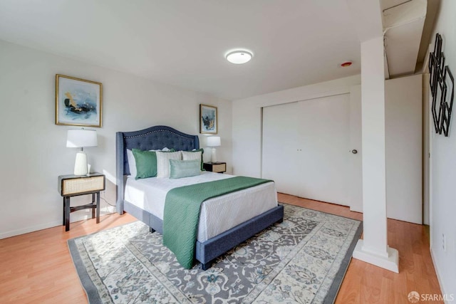 bedroom with a closet, baseboards, and wood finished floors