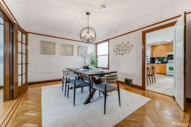 dining space featuring crown molding, baseboards, visible vents, and a notable chandelier