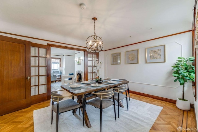 dining room featuring crown molding, baseboards, and an inviting chandelier