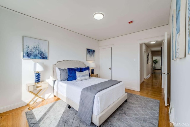 bedroom with light wood-type flooring and baseboards