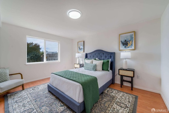 bedroom with wood finished floors and baseboards