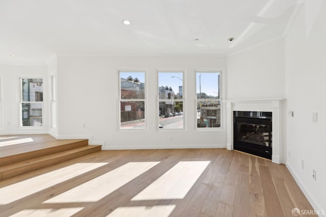 unfurnished living room featuring crown molding and light hardwood / wood-style flooring