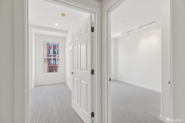 hallway featuring light colored carpet