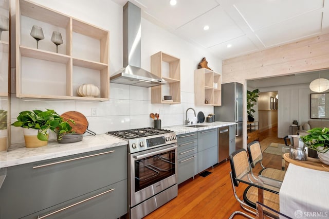 670 Page St, San Francisco, CA 94117 - kitchen with appliances with stainless steel finishes, gray cabinets, wall chimney range hood, open shelves, and light wood-style flooring