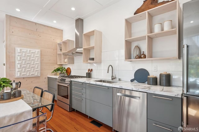 670 Page St, San Francisco, CA 94117 - kitchen with open shelves, appliances with stainless steel finishes, gray cabinets, wall chimney exhaust hood, and light wood-style floors