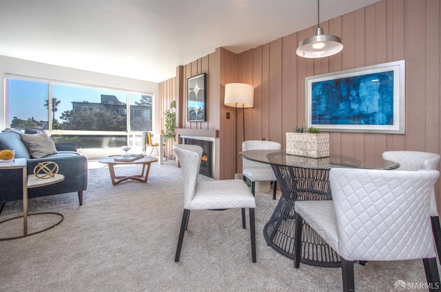 carpeted living room featuring wooden walls