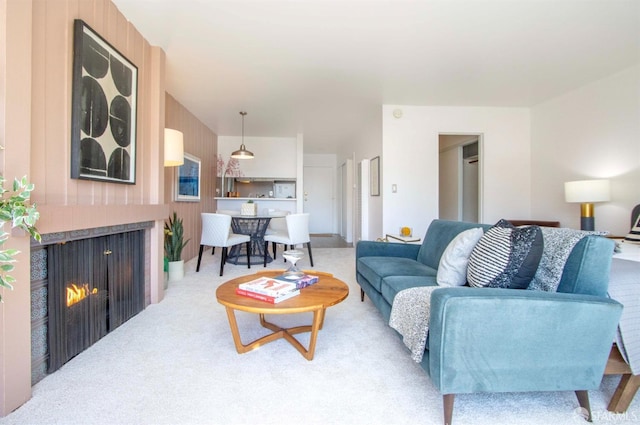 living room featuring a multi sided fireplace and light carpet