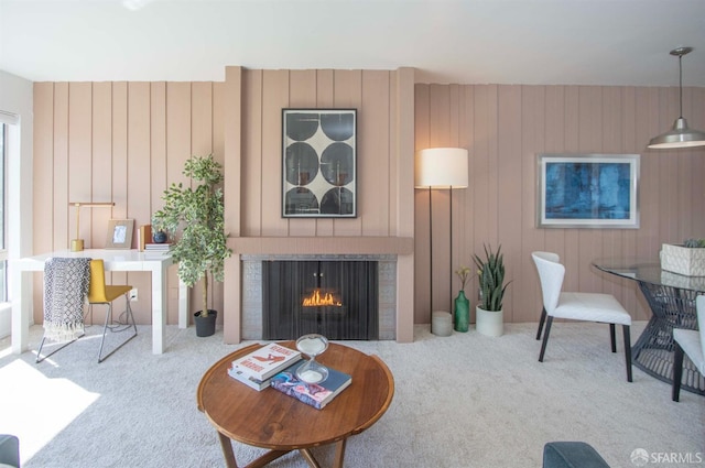 carpeted living area with a lit fireplace