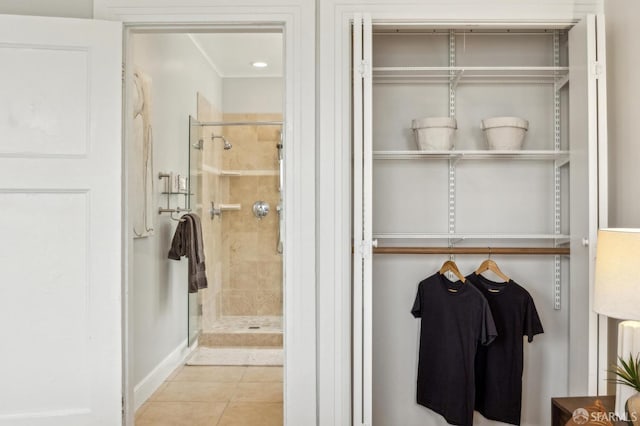 bathroom with a shower with door and tile patterned floors