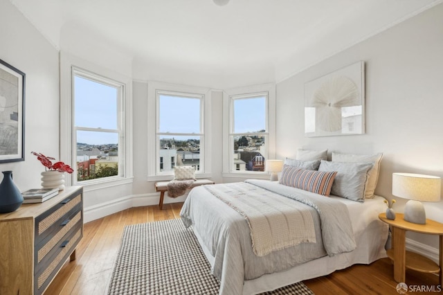 bedroom featuring multiple windows and light hardwood / wood-style flooring