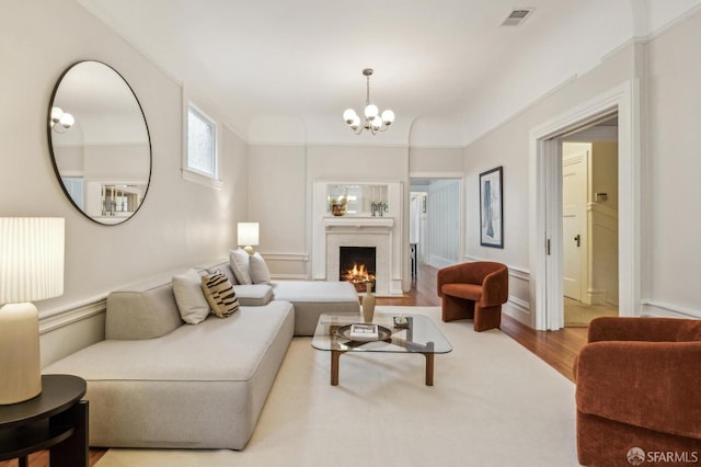 living room featuring a fireplace, a chandelier, and hardwood / wood-style floors