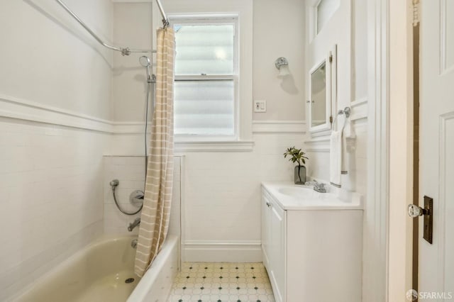 bathroom with shower / bathtub combination with curtain, vanity, and tile walls