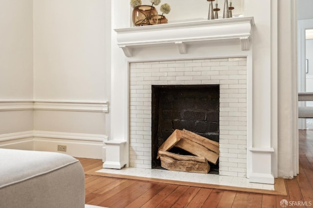 room details with a brick fireplace and wood-type flooring