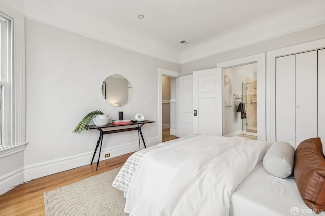 bedroom featuring connected bathroom and light wood-type flooring