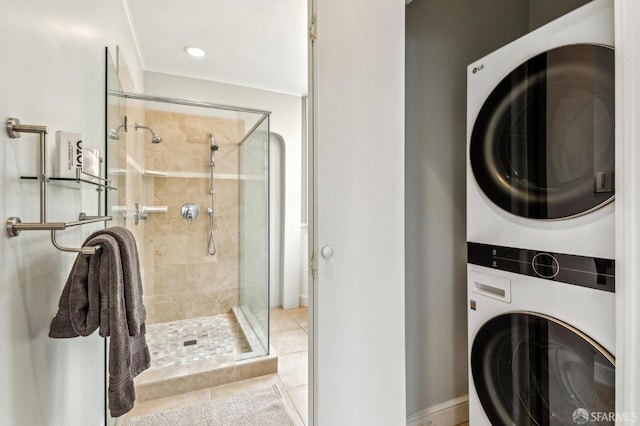 washroom with stacked washer and dryer and light tile patterned floors