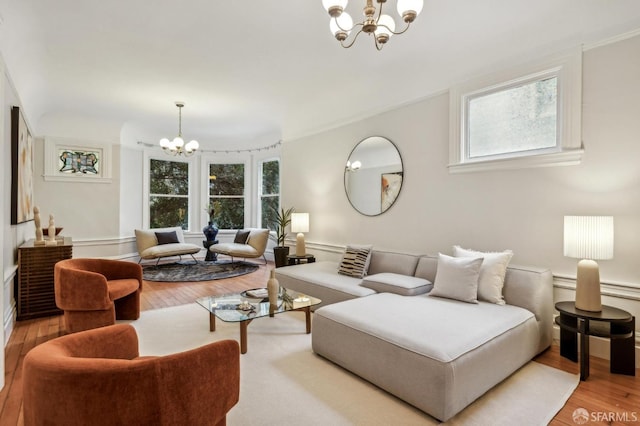 living room featuring plenty of natural light, light hardwood / wood-style floors, and a chandelier