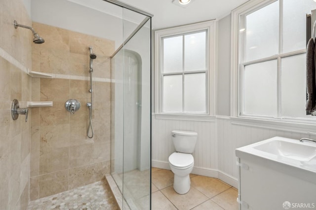 bathroom featuring tile patterned flooring, vanity, tiled shower, and toilet