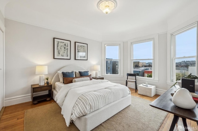 bedroom featuring multiple windows and hardwood / wood-style flooring