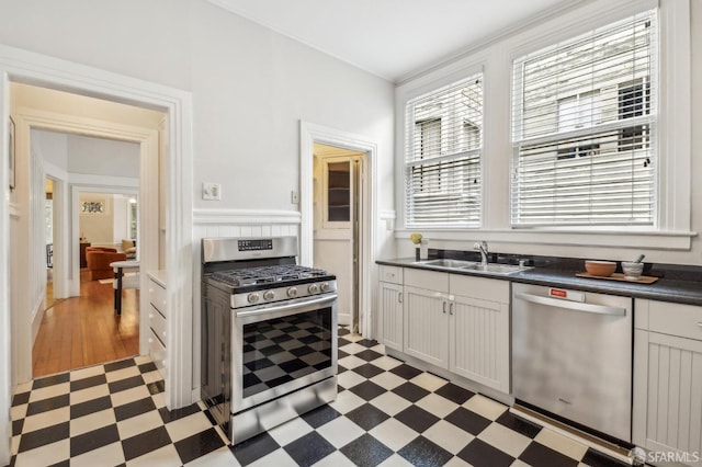 kitchen with appliances with stainless steel finishes, sink, and white cabinets